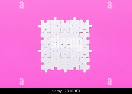 Détails blancs du puzzle sur fond rose. Détails du groupe de jeux - image Banque D'Images