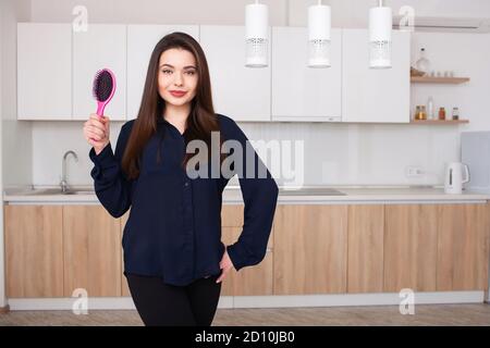 Girl est titulaire d'une brosse sans cheveux et souriant Banque D'Images