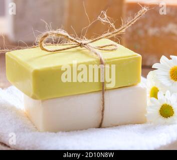 Savons de camomille faits maison. Porte-savon artisanal de couleur blanche et jaune, vue rapprochée. Cosmétiques naturels et sains à base de plantes Banque D'Images