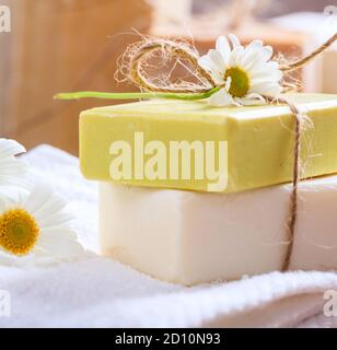 Savons de camomille faits maison. Porte-savon artisanal de couleur blanche et jaune, vue rapprochée. Cosmétiques naturels et sains à base de plantes Banque D'Images