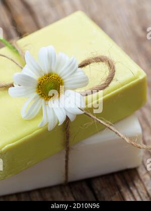 Savons de camomille faits maison. Porte-savon artisanal de couleur blanche et jaune, vue rapprochée. Cosmétiques naturels et sains à base de plantes Banque D'Images