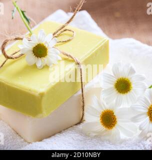 Savons de camomille faits maison. Porte-savon artisanal de couleur blanche et jaune, vue rapprochée. Cosmétiques naturels et sains à base de plantes Banque D'Images