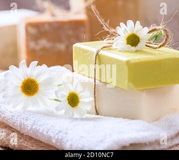 Savons de camomille faits maison. Porte-savon artisanal de couleur blanche et jaune, vue rapprochée. Cosmétiques naturels et sains à base de plantes Banque D'Images