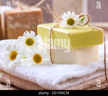 Savons de camomille faits maison. Porte-savon artisanal de couleur blanche et jaune, vue rapprochée. Cosmétiques naturels et sains à base de plantes Banque D'Images