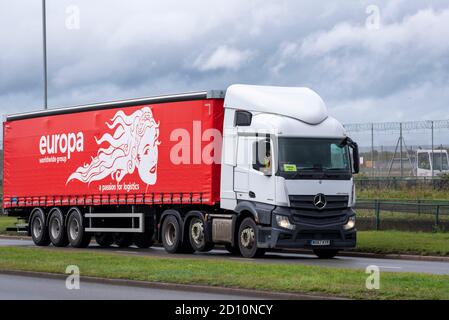 Groupe mondial Europa, transport, logistique, camion passant l'aéroport de Londres Heathrow, Royaume-Uni. Mercedes à rideau articulé, véhicule tautliner Banque D'Images