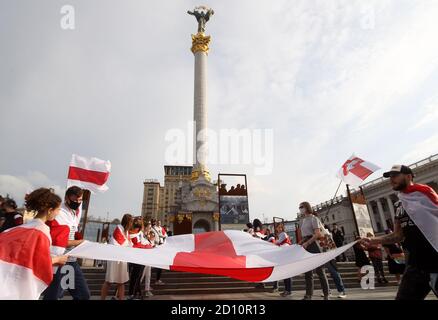 Des manifestants portant un grand drapeau blanc-rouge-blanc historique du Bélarus pendant le rassemblement.des citoyens biélorusses vivant en Ukraine et des militants ukrainiens ont participé à un rassemblement pour exprimer leur solidarité avec le mouvement de protestation en Biélorussie contre les résultats des élections présidentielles. Banque D'Images
