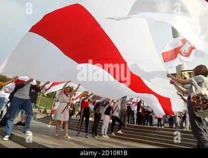 Des manifestants portant un grand drapeau blanc-rouge-blanc historique du Bélarus pendant le rassemblement.des citoyens biélorusses vivant en Ukraine et des militants ukrainiens ont participé à un rassemblement pour exprimer leur solidarité avec le mouvement de protestation en Biélorussie contre les résultats des élections présidentielles. Banque D'Images