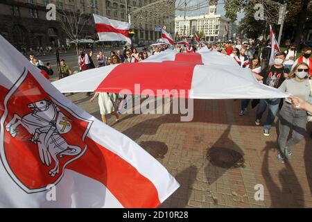 Des manifestants portant un grand drapeau blanc-rouge-blanc historique du Bélarus pendant le rassemblement.des citoyens biélorusses vivant en Ukraine et des militants ukrainiens ont participé à un rassemblement pour exprimer leur solidarité avec le mouvement de protestation en Biélorussie contre les résultats des élections présidentielles. Banque D'Images