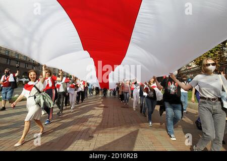 Les participants portant un grand drapeau historique blanc-rouge-blanc de la Biélorussie pendant le rassemblement.les citoyens biélorusses vivant en Ukraine et les militants ukrainiens ont participé à un rassemblement pour exprimer leur solidarité avec le mouvement de protestation en Biélorussie contre les résultats des élections présidentielles. Banque D'Images