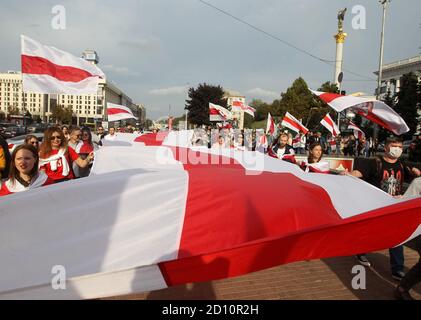 Des manifestants portant un grand drapeau blanc-rouge-blanc historique du Bélarus pendant le rassemblement.des citoyens biélorusses vivant en Ukraine et des militants ukrainiens ont participé à un rassemblement pour exprimer leur solidarité avec le mouvement de protestation en Biélorussie contre les résultats des élections présidentielles. Banque D'Images