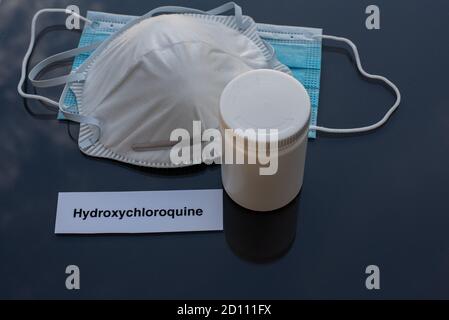 Hydroxychloroquine dans un gallium pour le traitement du covid-19 et deux masques comme protection sur le plateau de table réfléchissant noir, Danemark, 4 octobre 2020 Banque D'Images