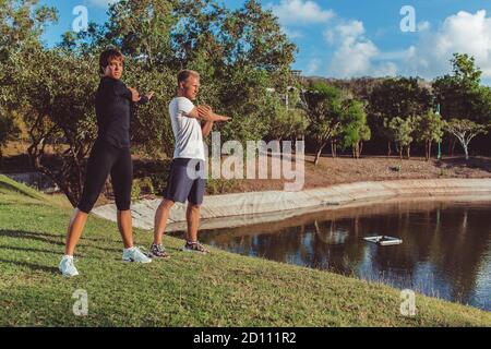 un gars avec une fille qui fait un échauffement dans le parc. Photo de haute qualité Banque D'Images