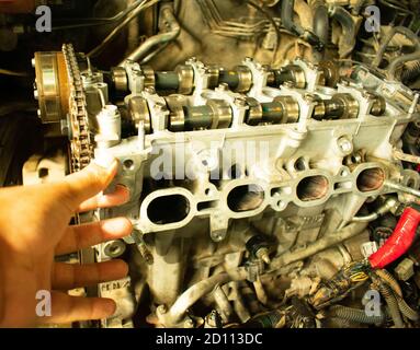 mécanicien réparateur vérifiant le moteur ouvert dans le centre automobile Banque D'Images