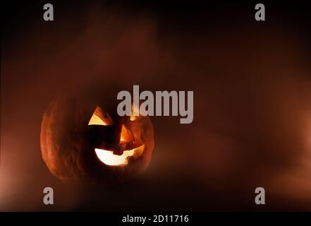 Jack o Lantern sur fond noir et avec un peu de brouillard. Banque D'Images