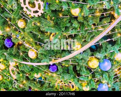 Arbre de Noël décoré de guirlandes et de boules dorées et bleues. Photo plein écran Banque D'Images