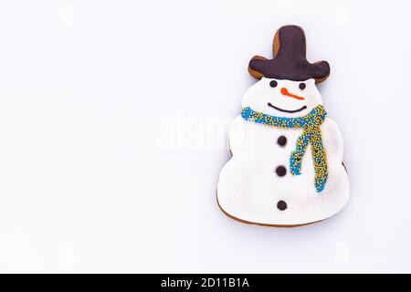 Pain d'épice en forme de bonhomme de neige sur fond blanc avec espace vide pour le texte. Banque D'Images