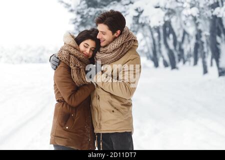 Couple adorable qui se tient debout dans la forêt de Snowy Walking en plein air Banque D'Images