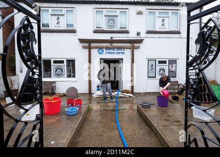 Aylesbury, Royaume-Uni. 4 octobre 2020. Tempête Alex inondation à Aylesbury, ville de comté de Buckinghamshire. Un week-end de forte pluie presque constante a fait éclater le ruisseau Bear ses banques menaçant des maisons dans la région de Californie de Southcourt et inondant le centre des arts martiaux et de conditionnement physique. Comme la pluie presque continue a diminué, le nettoyage du centre inondé d'arts martiaux et de conditionnement physique a commencé avec l'aide d'une pompe électrique et des seaux. Crédit : Stephen Bell/Alay Banque D'Images