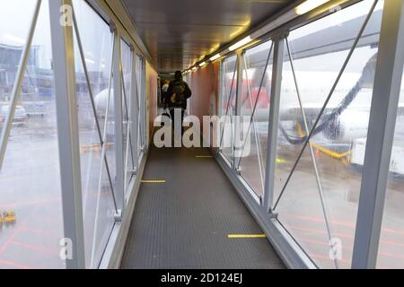 Passerelle d'embarquement des passagers (passerelle jet) avec des marques de sol pour la distanciation sociale due à la pandémie de coronavirus/Covid 19. Jetway avec marqueurs au sol. Banque D'Images