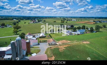 Vue aérienne de la campagne Amish avec des granges et des silos et une école d'une pièce le jour d'été ensoleillé Banque D'Images