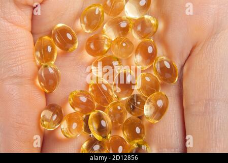 Les femmes main avec des capsules de gel de vitamine D . Vitamine Oméga-3 huile de poisson en capsules. Capsules de capsule transparentes à la main ou gel souple Banque D'Images