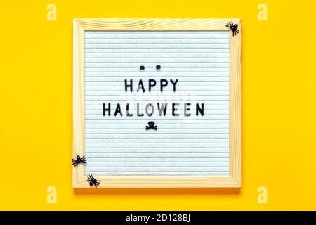 Tableau en feutre avec texte et araignées sur fond jaune Haut Afficher la carte de Noël concept créatif Happy Halloween Flat Lay Banque D'Images