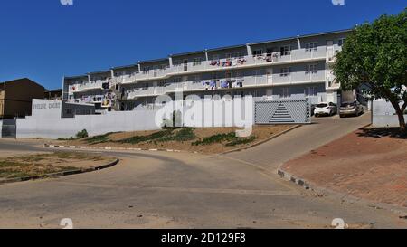 Windhoek, Namibie - 05/05/2018: Maison multi-famille sécurisée peinte en gris appelée 'Eveline court' au bord du canton de Katutura avec rue. Banque D'Images