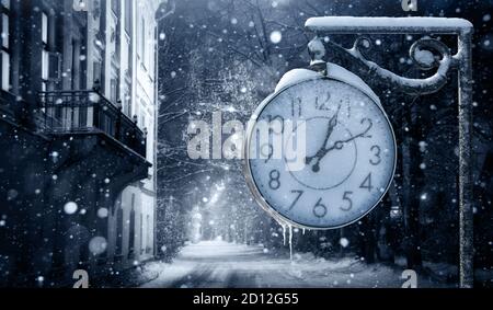 Street clock in winter. Change to winter time  Banque D'Images