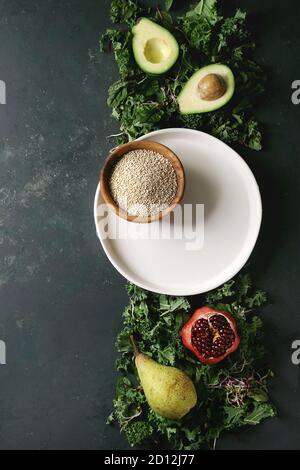 Salade verte et de fruits mélange salade avec le chou vert, les jeunes feuilles, les pousses de betterave, poire, avocat, grenade, bol de quinoa non cuits, videz la plaque. Dark Banque D'Images