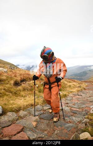 Lloyd Scott, collecteur de fonds vétéran, qui tente de grimper les trois sommets tout en portant un costume de plongée en haute mer, lors de son défi sur Ben Nevis en Écosse. Banque D'Images