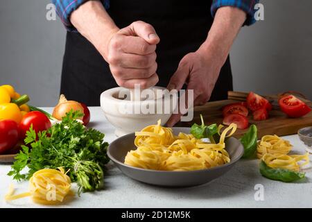 Cuisiner des pâtes à la maison, la main de l’homme Banque D'Images