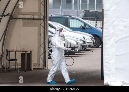 Paramédic portant un équipement de protection désinfectant poste de test mobile tente pour Voitures pendant l'épidémie de coronavirus ou de COVID19 Banque D'Images