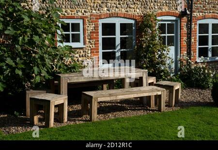 table en bois et chaises de banc dehors dans le jardin, Angleterre Banque D'Images