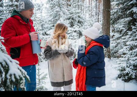 Thé chaud dans un thermos dans la forêt d'hiver. Un merveilleux séjour actif pour toute la famille dans un domaine de campagne en hiver pendant les vacances de Noël Banque D'Images