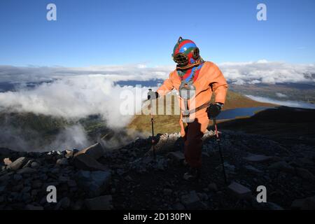 Lloyd Scott, collecteur de fonds vétéran, qui tente de grimper les trois sommets tout en portant un costume de plongée en haute mer, lors de son défi sur Ben Nevis en Écosse. Banque D'Images