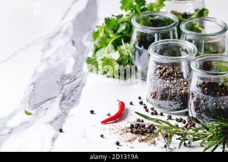 Variété de piment poivre noir, piment, poivre long, poivre des moines, le poivre et la poudre au sol dans des bocaux en verre avec piment et fre Banque D'Images