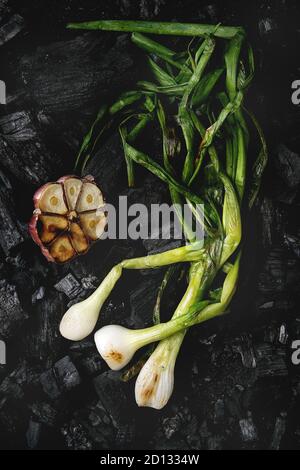 Légumes grillés petits oignons et l'ail à charbon noir. Vue de dessus, de l'espace. Concept de barbecue Banque D'Images