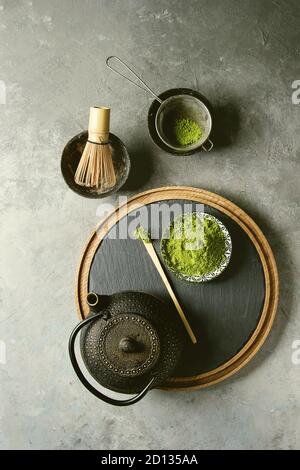 Ingrédients pour faire boire le matcha. Le thé vert matcha en poudre dans un bol en céramique, traditionnel bambou cuillère et fouetter sur ardoise, théière noire ove Banque D'Images