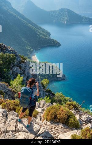 Jeune femme faisant la photo du beau paysage de la côte méditerranéenne près d'Antalya, Turquie. Banque D'Images