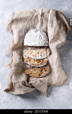 Tranches de gâteau de Noël traditionnel allemand, cuisson festive. Les stollen avec raisins secs et le sucre en poudre sur lin gris serviette sur la texture backgroun Banque D'Images