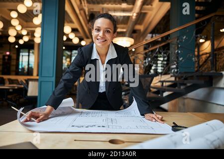 Positive ravie internationale féminine s'appuyant sur la table Banque D'Images