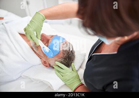 Un spa-thérapeute professionnel effectuant des procédures de soin de la peau pour un client Banque D'Images