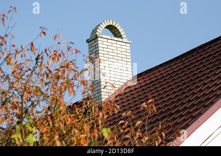 Cheminée en brique blanche sur le toit de la maison. Banque D'Images