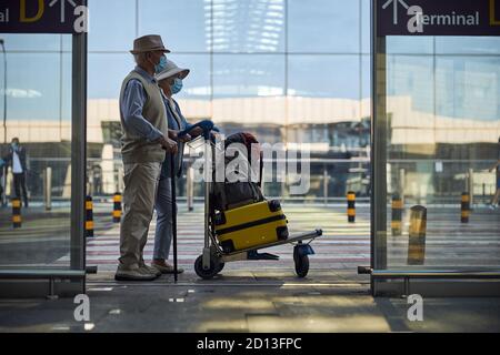 Couple de personnes âgées avec des bagages en vue de la distance Banque D'Images