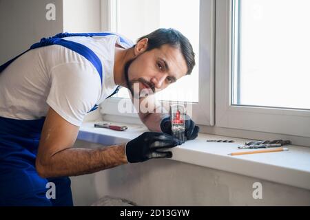 Le contremaître a mis un niveau laser sur le seuil de la fenêtre et marque Banque D'Images