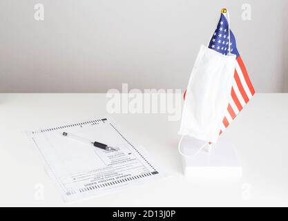 COVID 19 et le concept de vote officiel général. Le masque médical de protection est placé sur le drapeau des États-Unis. Le bulletin de vote papier est sur la table. Un choix meilleur Banque D'Images