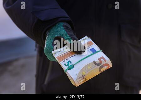 01 octobre 2020, Saxe, Breitenau A17: Les agents des douanes tiennent un paquet de billets de banque entre leurs mains. Les billets de 50 euros sont détenus par une bande élastique. Photo: Tino Plunert/dpa-Zentralbild/ZB Banque D'Images