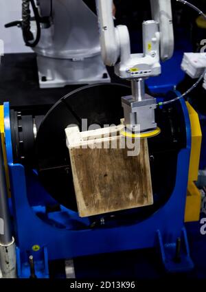 Automated robotic arm polishing wooden chair. Hi-technology industrial manufacturing Banque D'Images