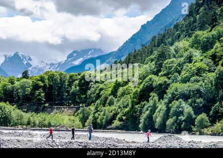 un groupe de touristes se promène le long des rives d'un rivière stormy dans les montagnes Banque D'Images