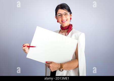 Un élégant professeur de brunette montrant quelque chose sur un tableau blanc vide. Formation en ligne Banque D'Images